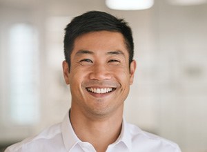 Man in white shirt in the office smiling