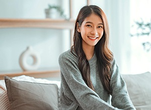 Smiling woman sitting on couch at home