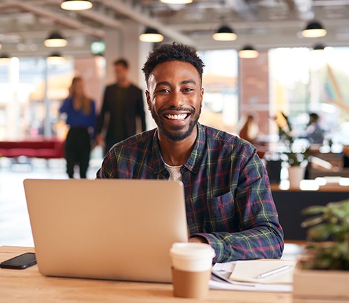 Man smiling while working on laptop