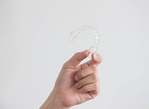 Closeup of patient holding clear aligner