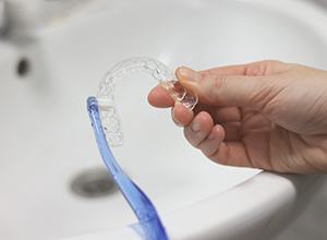 Cleaning clear aligner with toothbrush