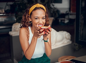 Woman smiling while enjoying cup of coffee