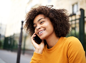 Woman smiling while talking on phone outside