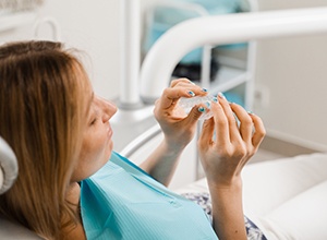 Patient holding clear aligner in treatment room