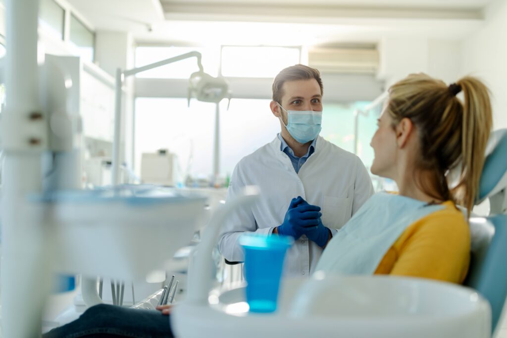 Dentist talking to patient in treatment chair