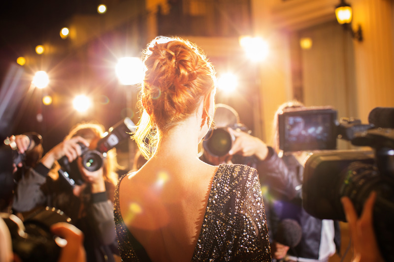 Celebrity with dental implants smiling on red carpet