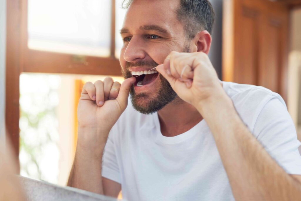 Man flossing his teeth